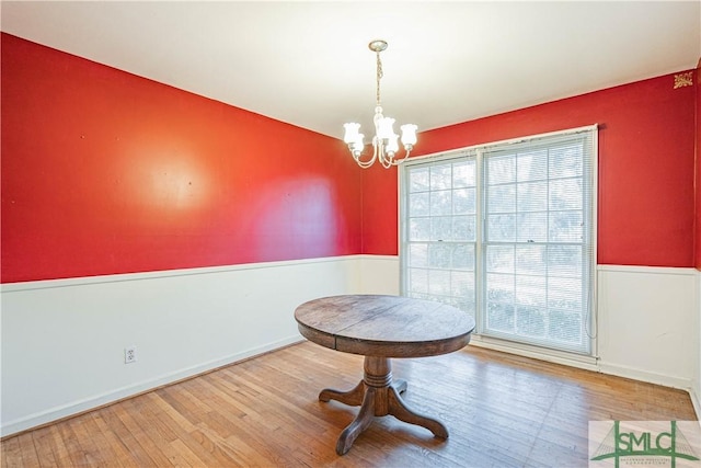 dining space featuring wood-type flooring, an inviting chandelier, and plenty of natural light