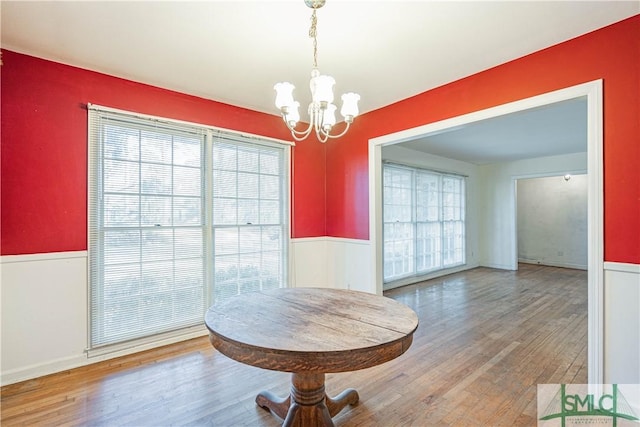 dining area with hardwood / wood-style flooring and a notable chandelier