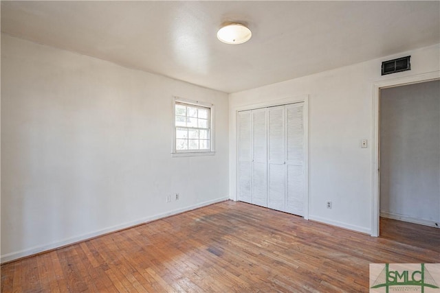 unfurnished bedroom with hardwood / wood-style flooring and a closet