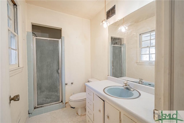 bathroom with tile patterned floors, vanity, toilet, and a shower with shower door