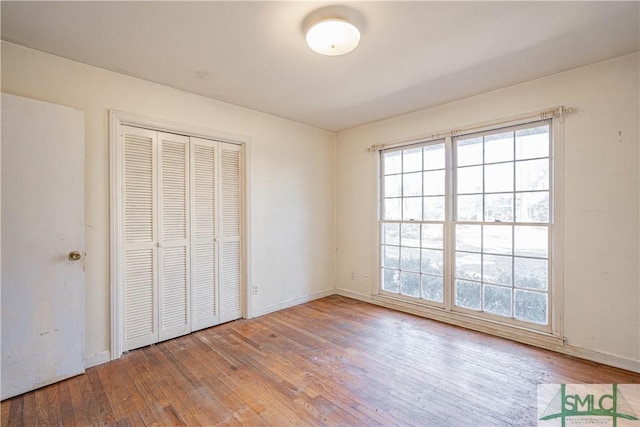 unfurnished bedroom with light hardwood / wood-style flooring and a closet