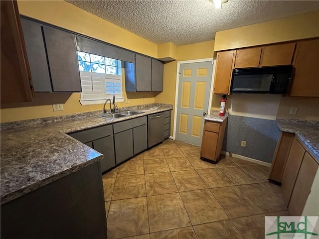 kitchen with dishwasher, sink, light tile patterned floors, and a textured ceiling