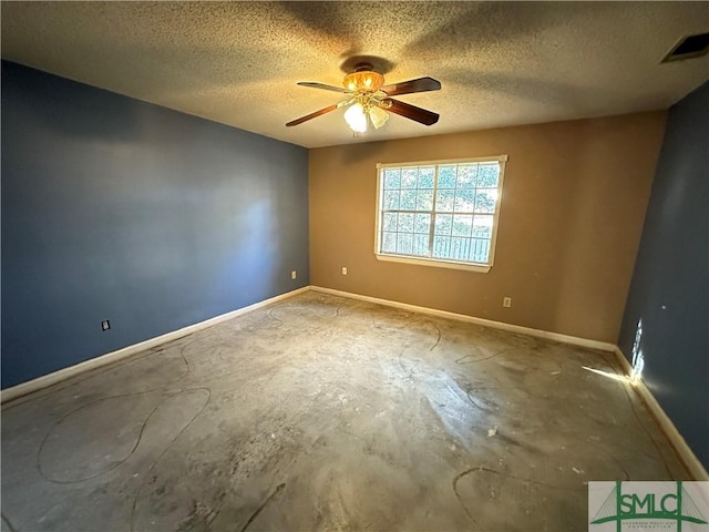 empty room with ceiling fan, concrete flooring, and a textured ceiling