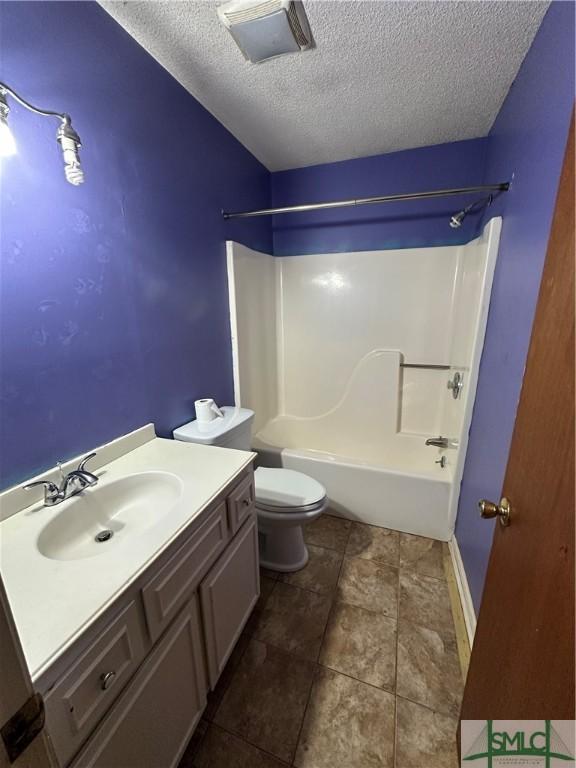 full bathroom featuring vanity, a textured ceiling, toilet, and  shower combination