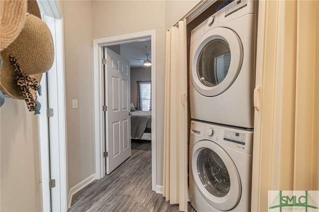 laundry area featuring dark hardwood / wood-style floors, ceiling fan, and stacked washer / drying machine