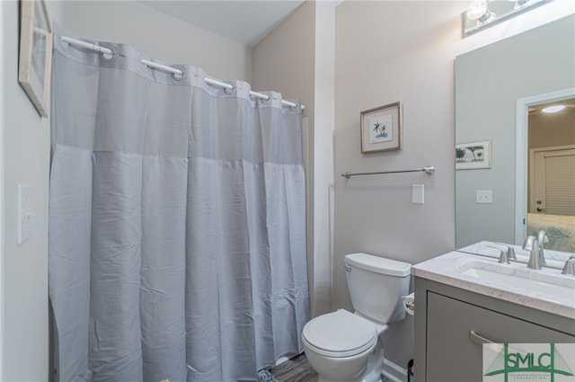 bathroom featuring a shower with shower curtain, vanity, and toilet