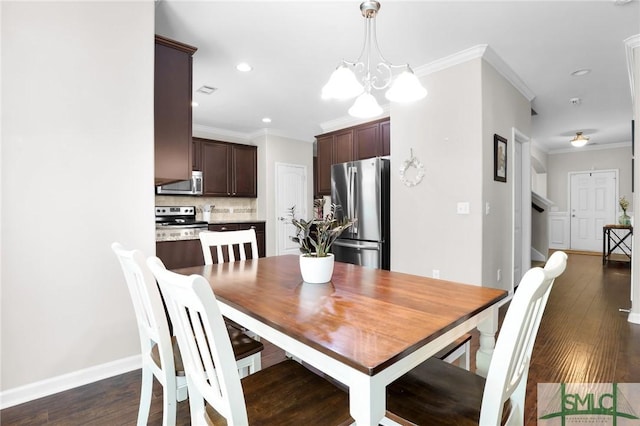 dining space featuring ornamental molding, dark hardwood / wood-style floors, and an inviting chandelier