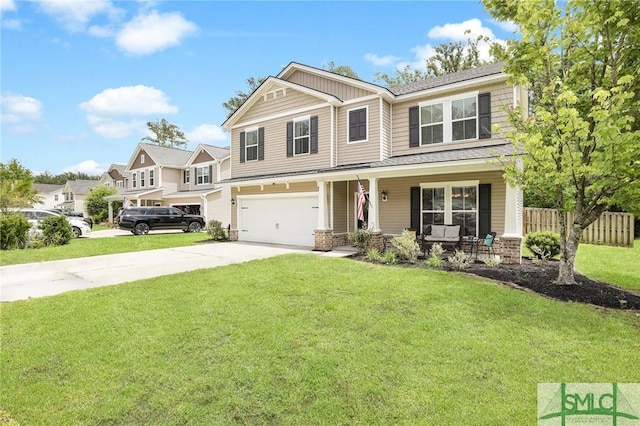 view of front of property featuring covered porch, a garage, and a front lawn