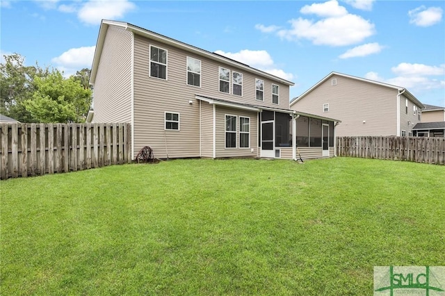 rear view of house with a sunroom and a lawn