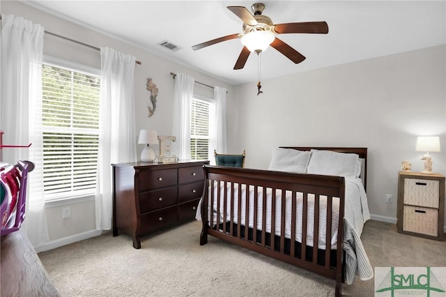 carpeted bedroom with ceiling fan and multiple windows