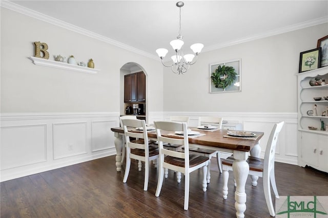 dining room featuring dark hardwood / wood-style flooring, ornamental molding, and an inviting chandelier