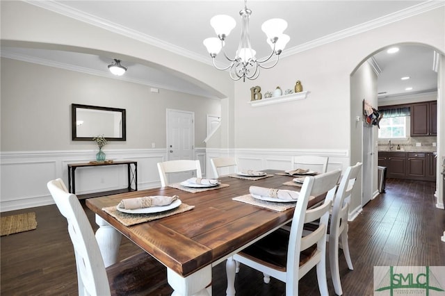 dining space featuring crown molding, sink, dark hardwood / wood-style floors, and a notable chandelier