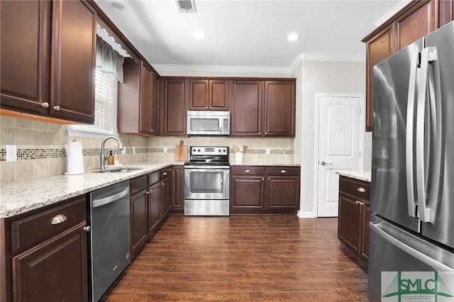 kitchen with appliances with stainless steel finishes, backsplash, ornamental molding, and sink