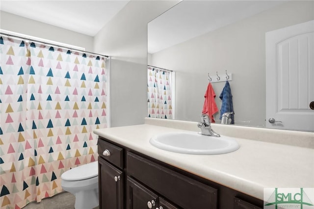 bathroom with curtained shower, vanity, and toilet