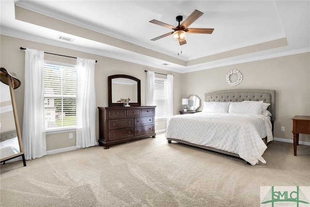 bedroom featuring multiple windows, light colored carpet, a raised ceiling, and ceiling fan