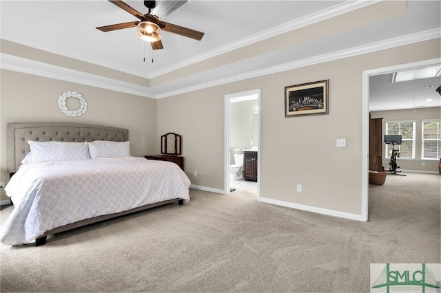 bedroom with light carpet, ensuite bathroom, ornamental molding, a raised ceiling, and ceiling fan