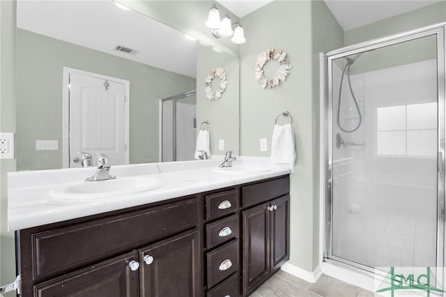 bathroom featuring tile patterned floors, vanity, and a shower with shower door