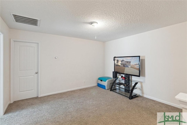 interior space featuring a textured ceiling and light colored carpet