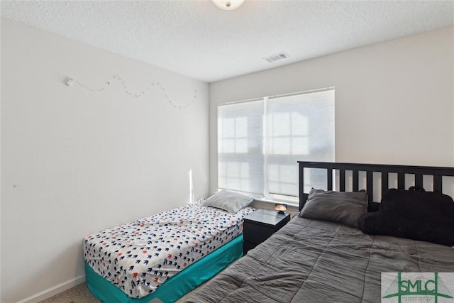 bedroom with a textured ceiling and carpet floors