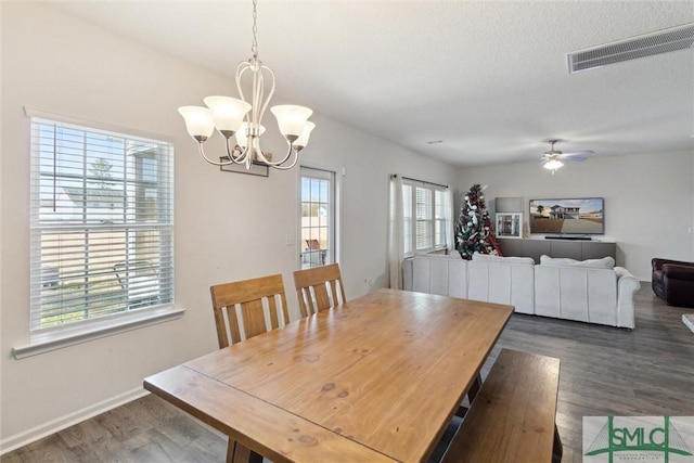 dining room with dark hardwood / wood-style flooring, ceiling fan with notable chandelier, and a textured ceiling