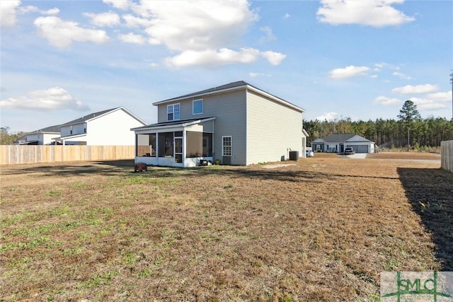 back of property with a sunroom and a lawn