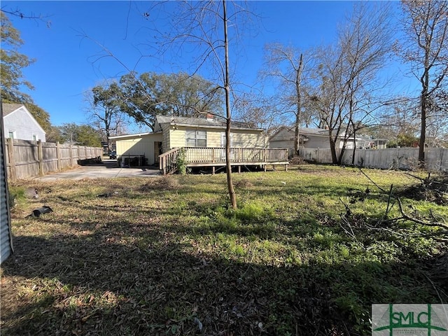 view of yard featuring a wooden deck and a patio area