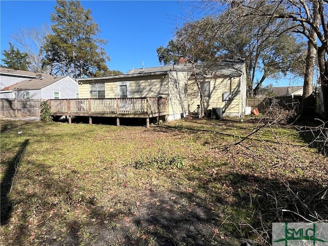 rear view of house featuring a deck and a lawn