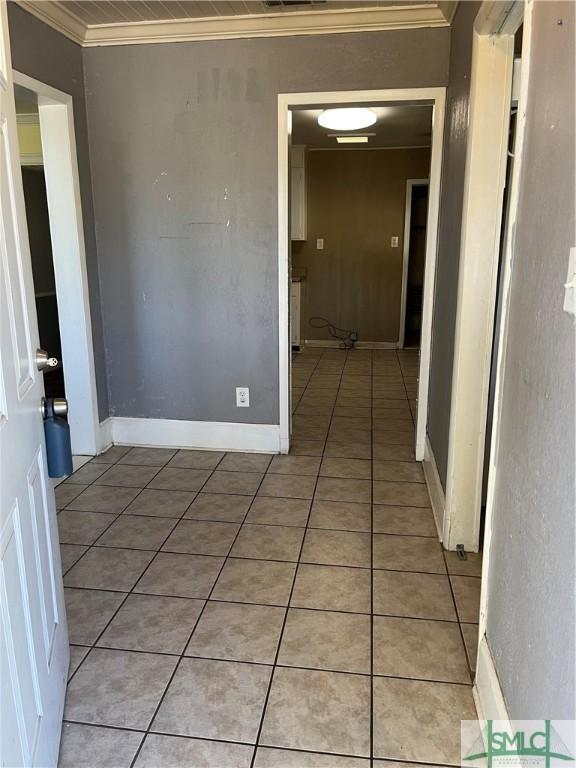 hall featuring ornamental molding and tile patterned floors