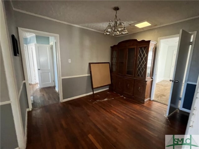 unfurnished dining area with ornamental molding, a chandelier, and dark hardwood / wood-style flooring