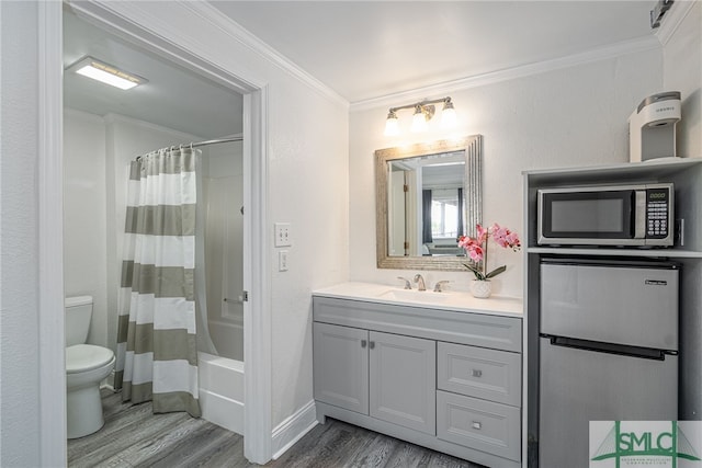 full bathroom with ornamental molding, vanity, wood-type flooring, and toilet