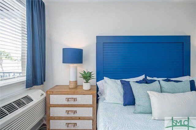 bedroom with heating unit and a wall mounted air conditioner