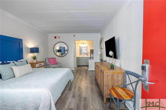 bedroom featuring connected bathroom, hardwood / wood-style flooring, and crown molding