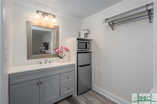 16 Tybrisa St Unit 127, Tybee Island, GA 31328 - bathroom featuring vanity, wood finished floors, and crown molding