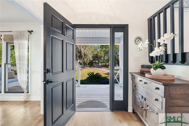 entryway featuring a wealth of natural light, light hardwood / wood-style floors, and ornamental molding