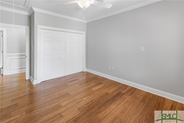 unfurnished bedroom featuring ceiling fan, ornamental molding, hardwood / wood-style floors, and a closet