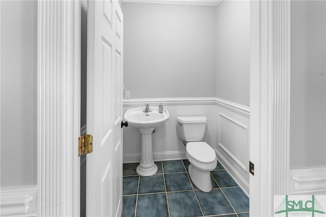 bathroom with toilet, tile patterned flooring, and sink