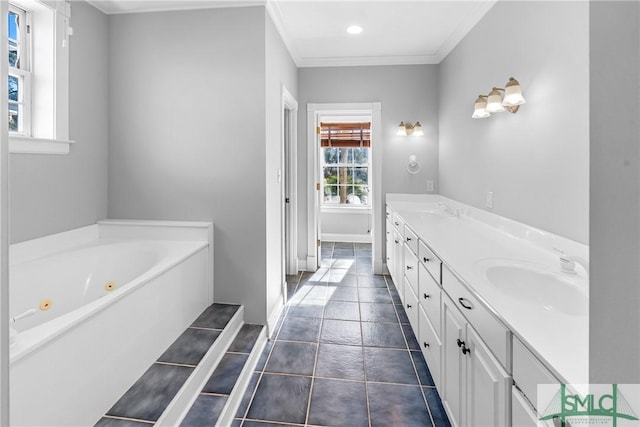 bathroom with ornamental molding, a tub to relax in, and vanity