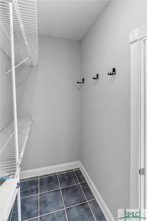 walk in closet with dark tile patterned floors