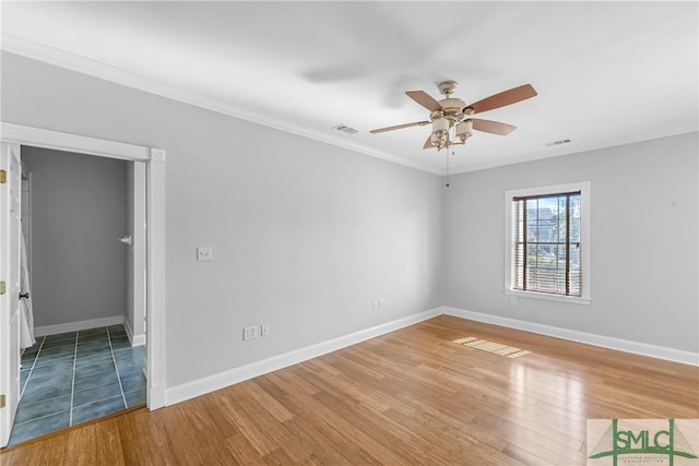 empty room featuring ceiling fan, crown molding, and wood-type flooring