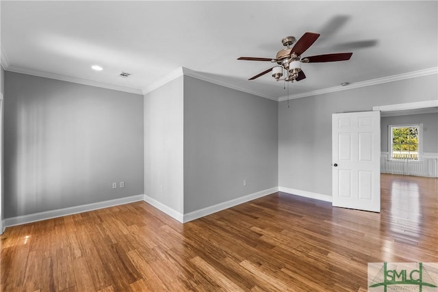 empty room featuring hardwood / wood-style flooring, ornamental molding, and ceiling fan