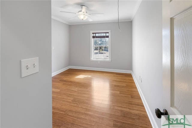 spare room featuring wood-type flooring, ornamental molding, and ceiling fan