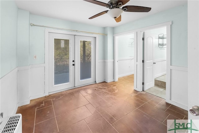 interior space with ceiling fan, french doors, and dark tile patterned floors