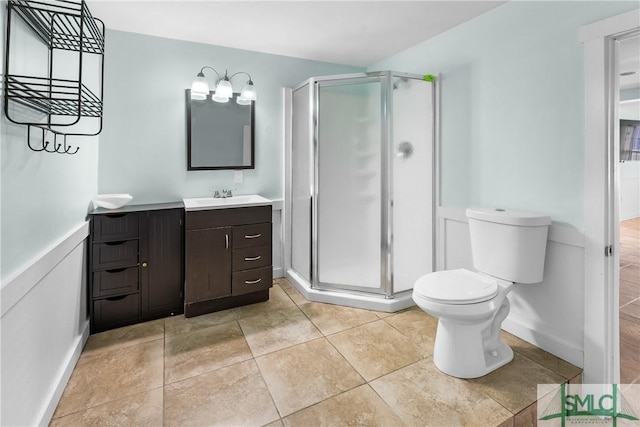 bathroom with walk in shower, tile patterned floors, vanity, and toilet