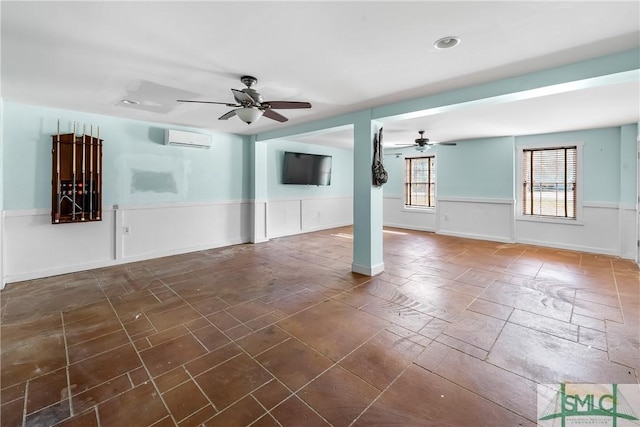 spare room with an AC wall unit and ceiling fan