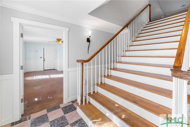 stairs with ceiling fan and crown molding