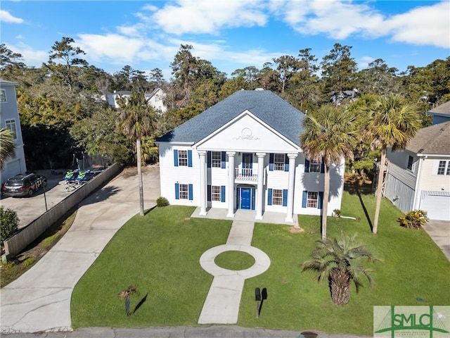 view of front of home with a balcony and a front yard