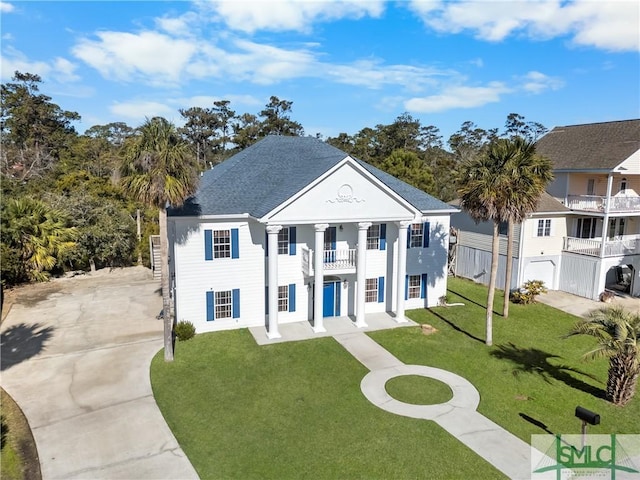 view of front of house with a balcony, a front lawn, and a garage