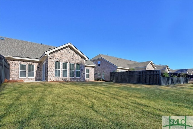 rear view of house featuring a lawn