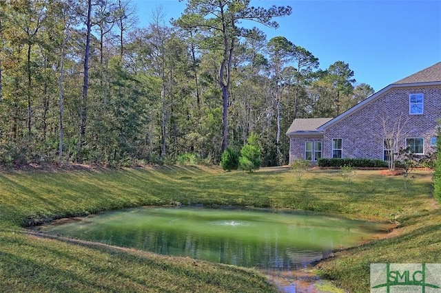 view of property's community with a water view and a yard