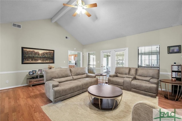 living room with french doors, ceiling fan, beam ceiling, high vaulted ceiling, and light hardwood / wood-style flooring